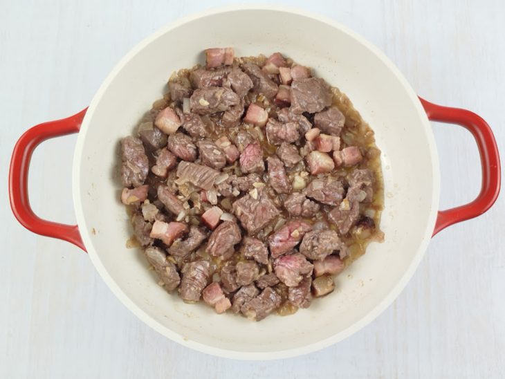 Bacon e carne adicionados na panela.