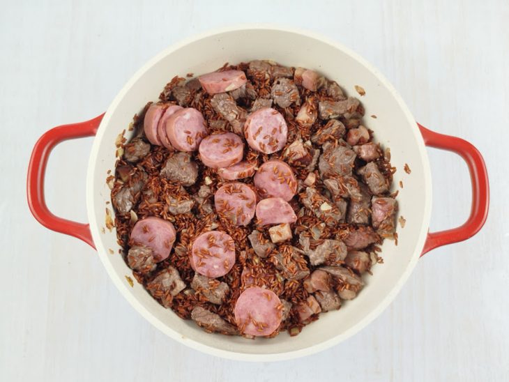 Arroz e calabresa adicionados na panela.