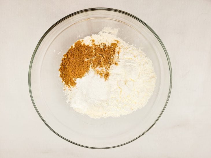 Um recipiente contendo farinha de trigo, amido de milho, curry, fermento químico e sal.