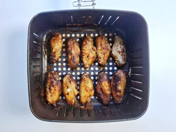 Asinhas viradas para o outro lado dentro da air fryer.