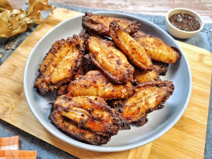 Asinhas de frango prontas para consumo em um prato.