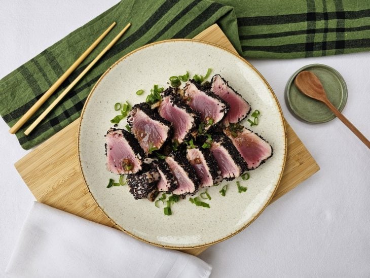 Um prato contendo atum com crosta de quinoa.