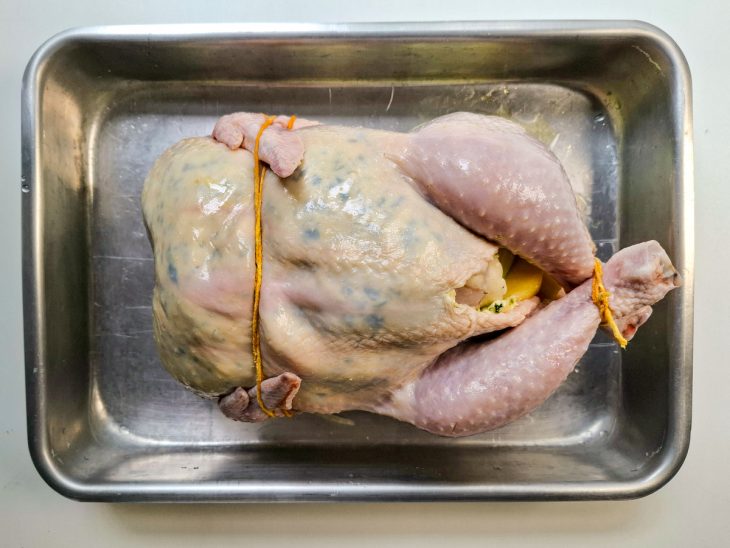 Na assadeira, a pele da ave recheada com a mistura de manteiga e ervas.