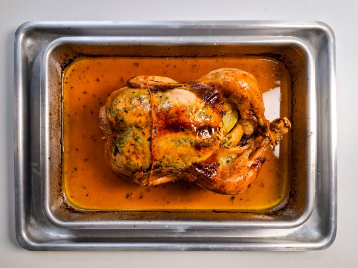 Assadeira sem o papel alumínio, ave já dourada.