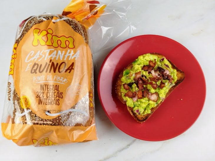 Mistura de avocado e bacon acomodados sobre a fatia de pão torrado.