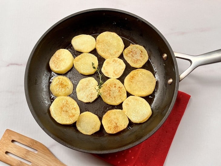 Uma frigideira com rodelas de batatas fritas.