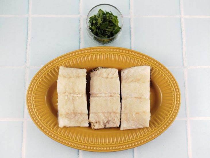 Bacalhau dessalgado em lascas grossas.