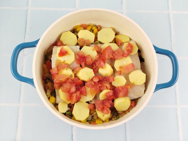 Tomates picados espalhados sobre a preparação.