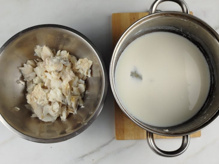 Panela com leite e outro recipiente com o bacalhau desfiado.