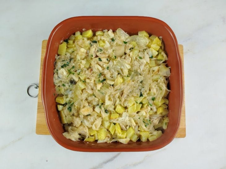 Refratário com bacalhau e batatas misturadas.