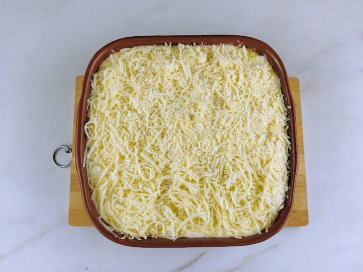 Um refratário com bacalhau com natas antes de assar.