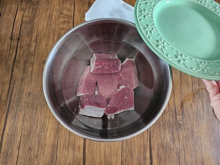 Um recipiente contendo carne-seca e água.