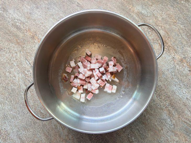 Numa panela, o óleo e o bacon.