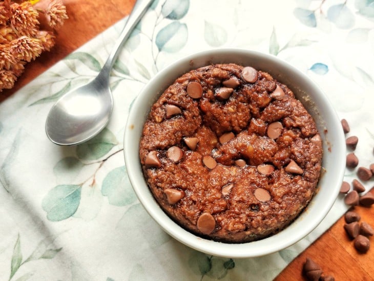 Baked oats pronto em ramequim com colher ao lado.