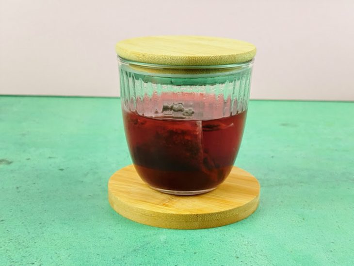 Chá em infusão numa caneca tampada.