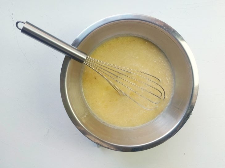 Um recipiente contendo a mistura de ovos batidos, banana e essência.
