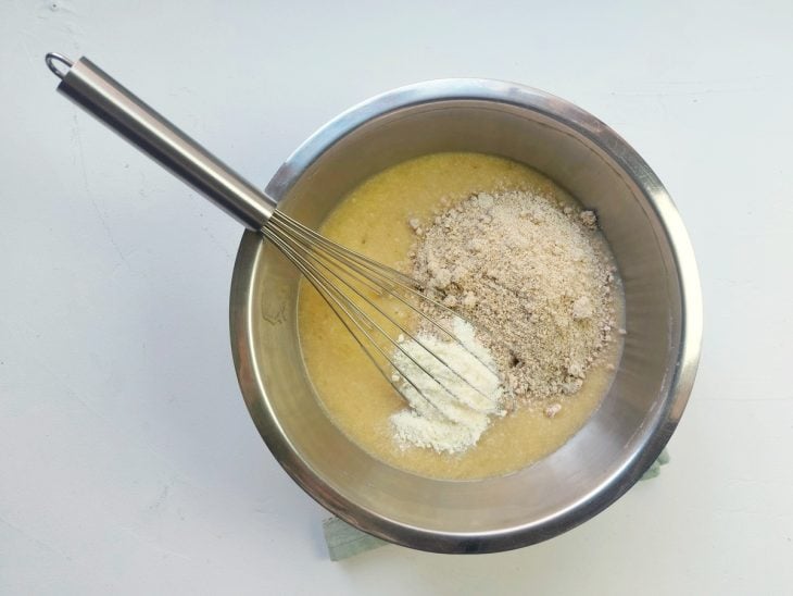 Um recipiente contendo a mistura de ovos batidos, banana, essência, Whey e aveia.