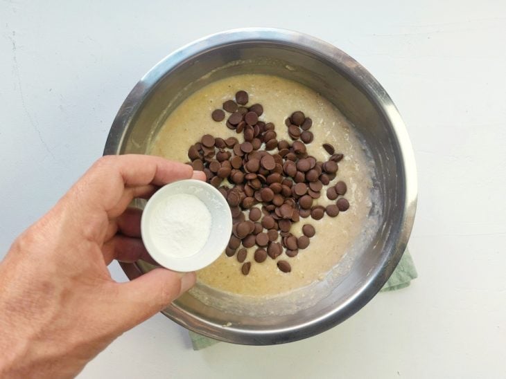 Um recipiente contendo a mistura de ovos batidos, banana, essência, Whey, aveia, fermento e chocolate.