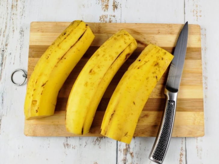 Bananas com as pontas cortadas sobre uma tábua.