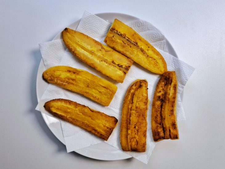 Fatias de bananas fritas sobre o prato com papel-toalha.