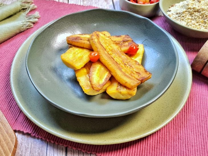 Banana da terra frita pronta para consumo, finalizada com pimenta-biquinho.