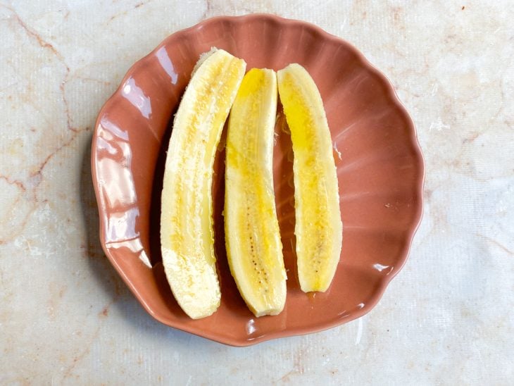 Manteiga de coco espalhada sobre as fatias de banana.
