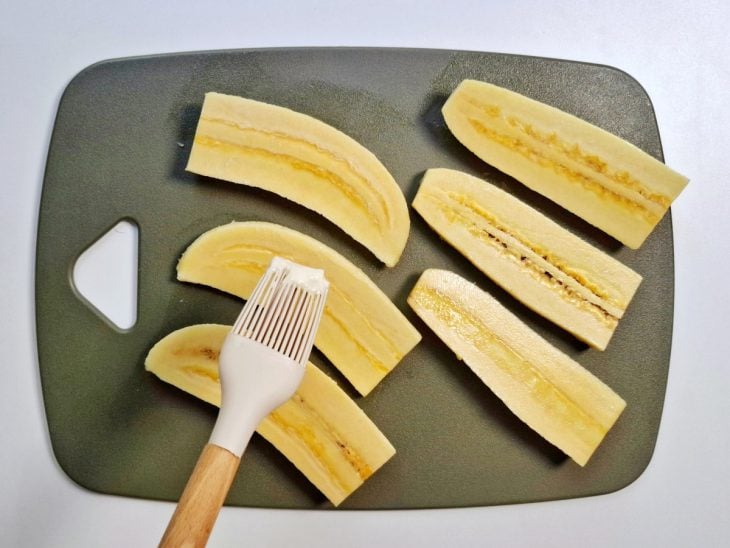 Manteiga pincelada nas fatias de banana.