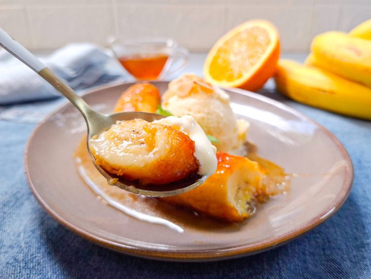 Porção de banana flambada e sorvete numa colher.