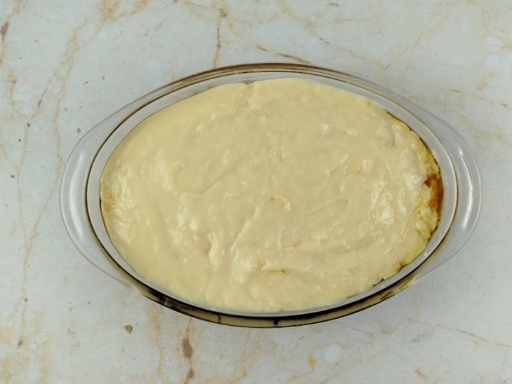 Creme branco despejado sobre a banana em rodelas.