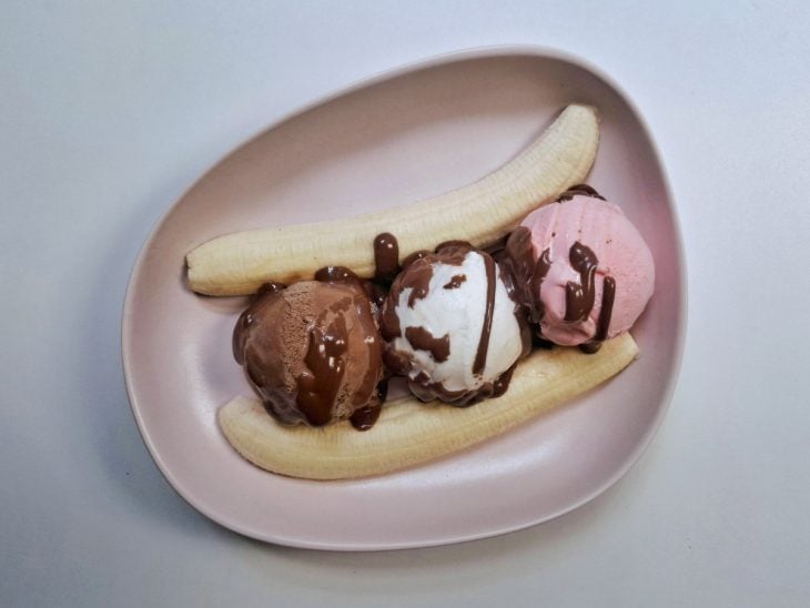 Cobertura de chocolate adicionada sobre as bolas de sorvete.
