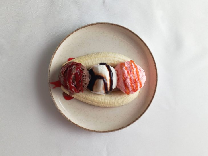 Um prato com banana, sorvete e a cobertura.