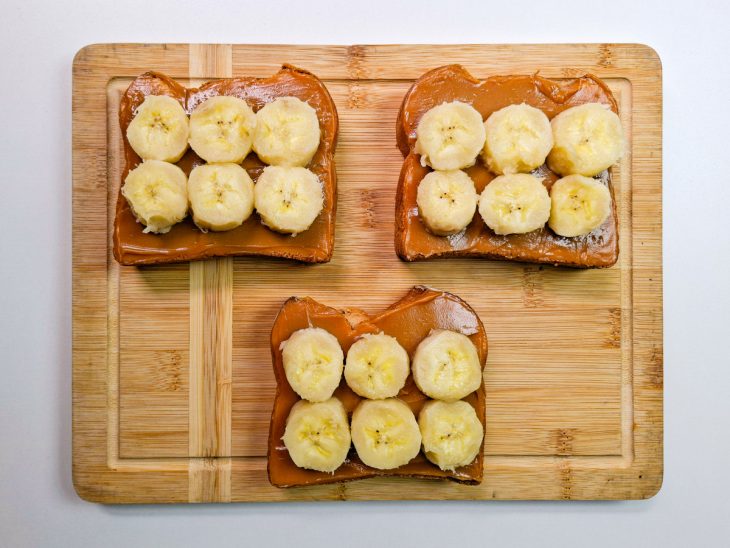 Rodelas de banana dispostas lado a lado sobre o doce de leite.