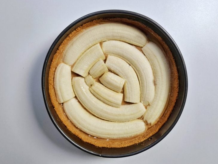 Bananas adicionadas sobre o doce de leite.