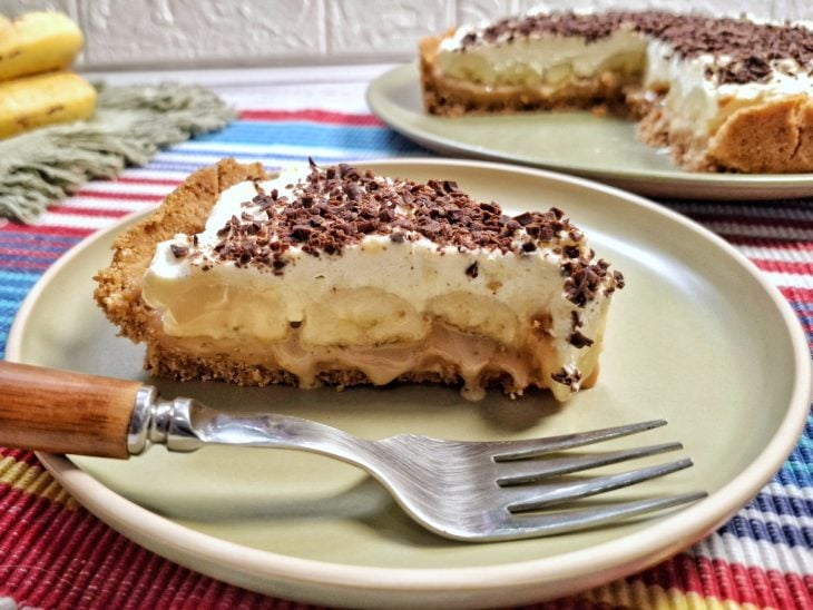 Fatia de banoffee sobre um prato redondo, pronto para consumo.