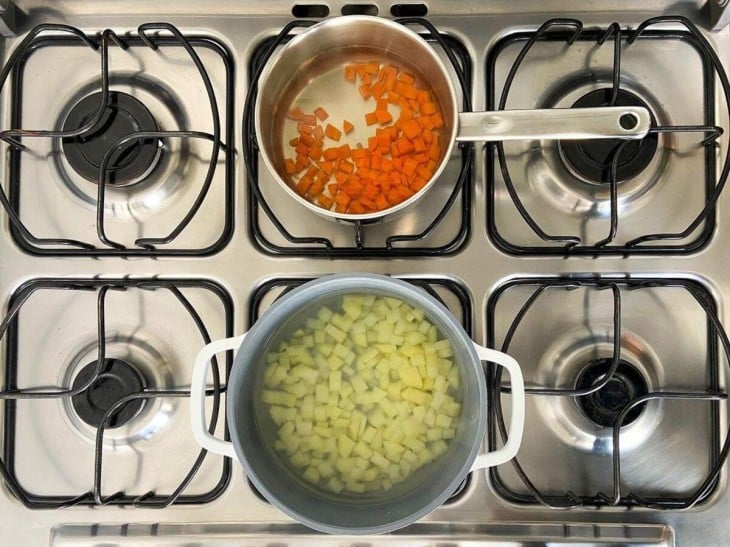 Duas panelas com batatas e cenouras cozidas.