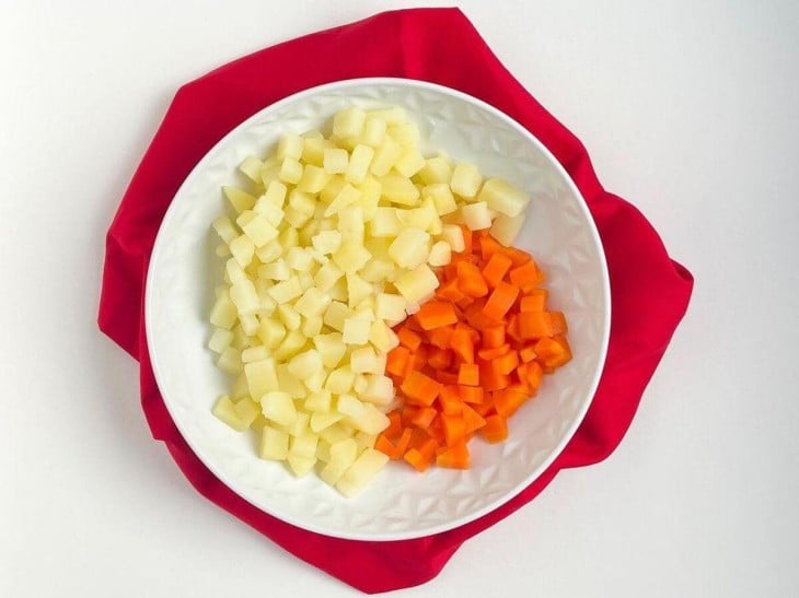 Um prato com as cenouras e batatas cozidas.