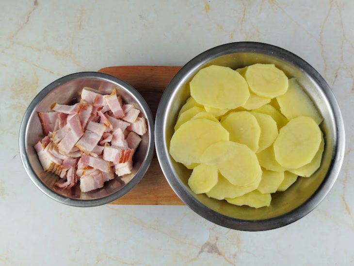 Batatas cortadas em rodelas e bacon picado em cubos.