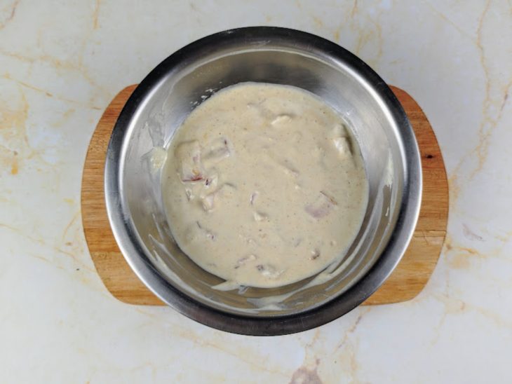 Creme de leite, noz-moscada, creme de cebola e bacon misturados em uma tigela.
