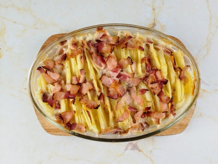 Batata assada com creme de leite e bacon na travessa.