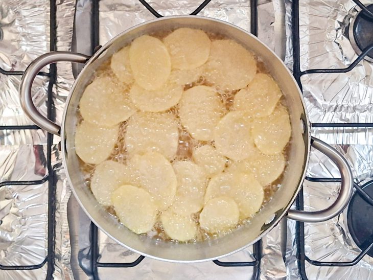 Batatas sendo fritas no óleo.