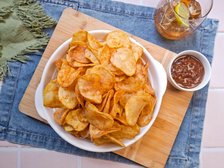 Batatas chips prontas, servidas com molho.