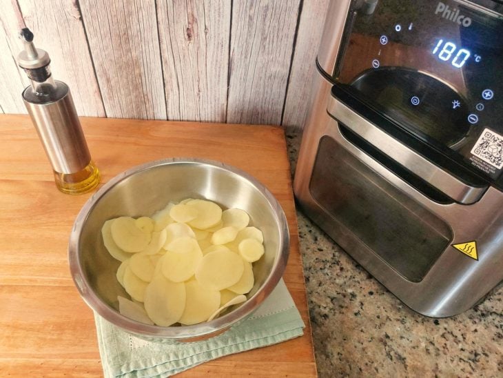 Um recipiente contendo batatas fatiadas.