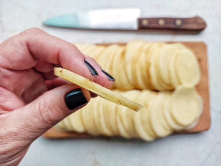 Batatas cortadas em rodelas finas.