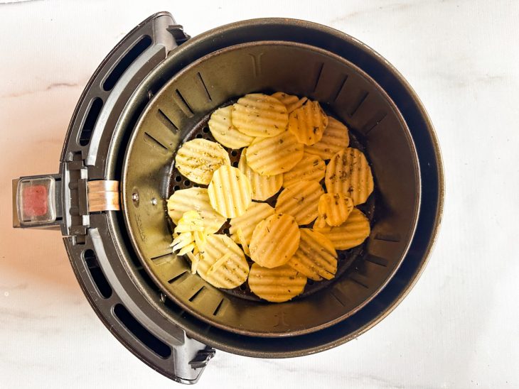 Batatas transferidas para o cesto da air fryer.