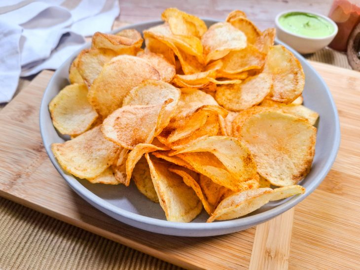 Batatas chips simples servidas num recipiente redondo.