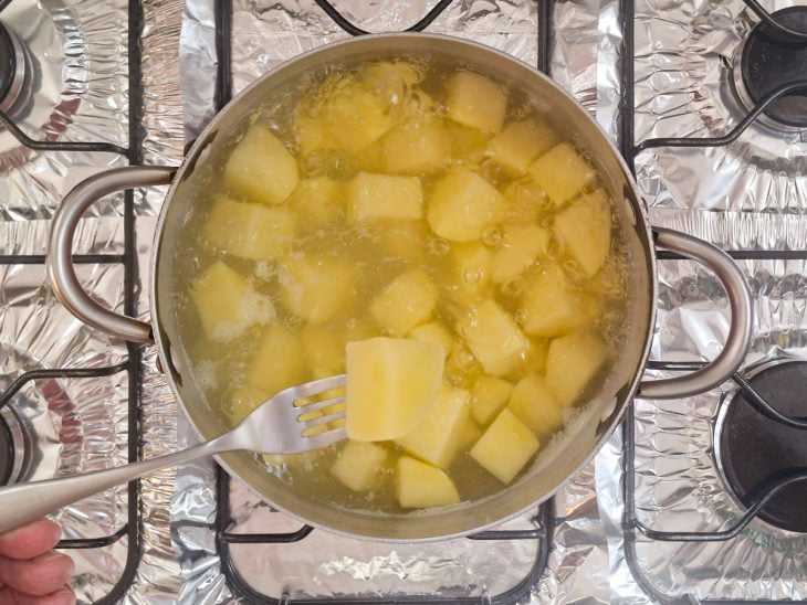 Batatas em cubos cozinhando na panela.