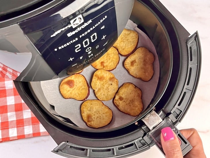 Uma airfryer contendo batatas-doces.