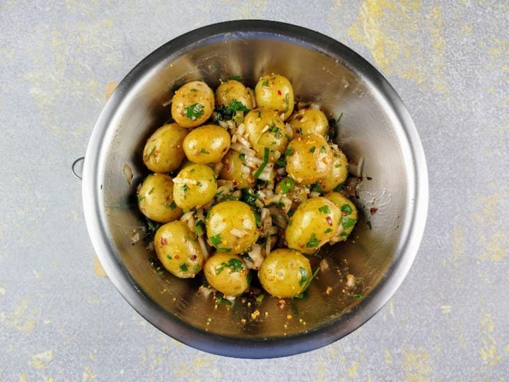 Batatas temperadas com pimenta-calabresa, sementes de mostarda, pimenta-do-reino, azeite, caldo de limão, cebolinha, salsinha, cebola e alho picado.