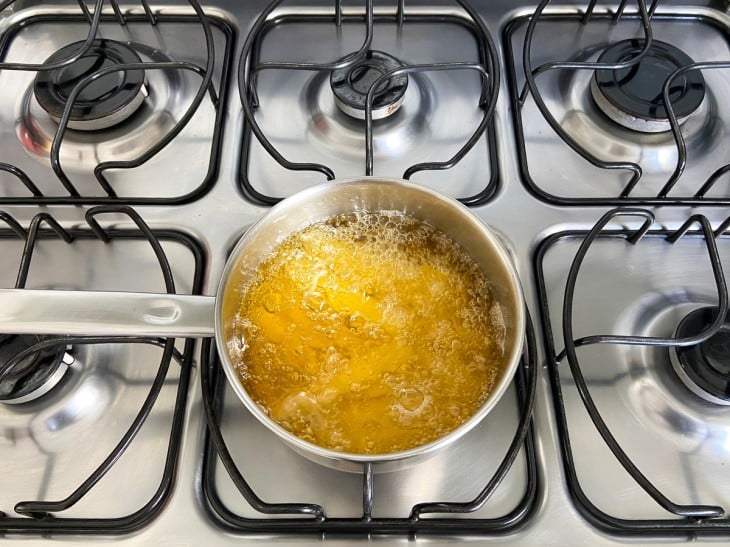 Uma frigideira com óleo fritando as batatas.
