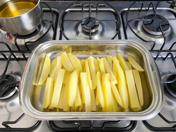 Um recipiente com as batatas pré-fritas.